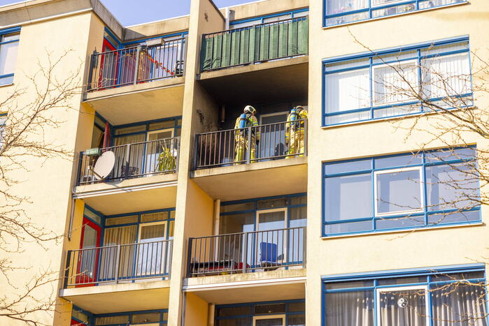 Brandweer blust brand op balkon