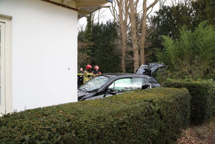 Auto crasht tegen woning