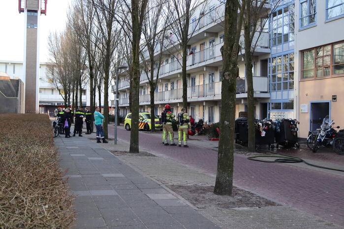 Containers vliegen in brand in flatgebouw