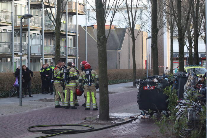 Containers vliegen in brand in flatgebouw