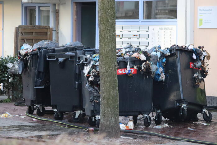 Containers vliegen in brand in flatgebouw