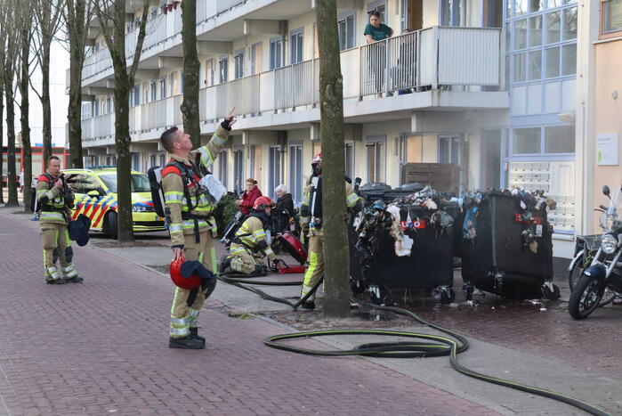 Containers vliegen in brand in flatgebouw
