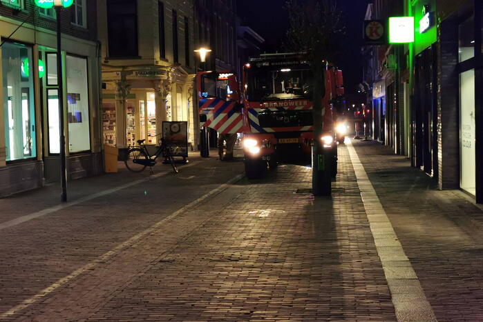Brandweer blust brand in woning boven winkel