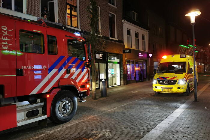 Brandweer blust brand in woning boven winkel