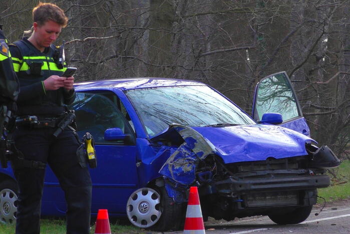 Auto in de kreukels na botsing tegen boom