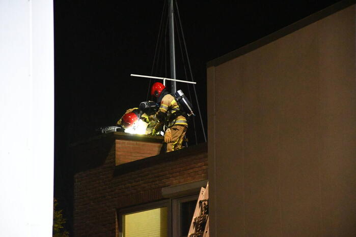 Brandweer blust brand in schoorsteen
