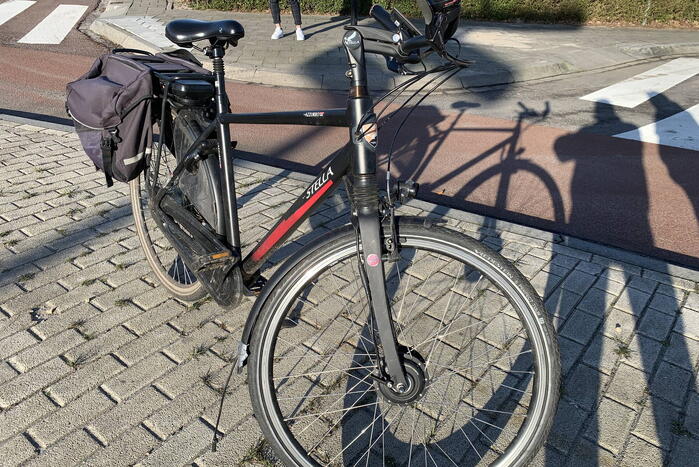 Auto schept e-biker op rotonde