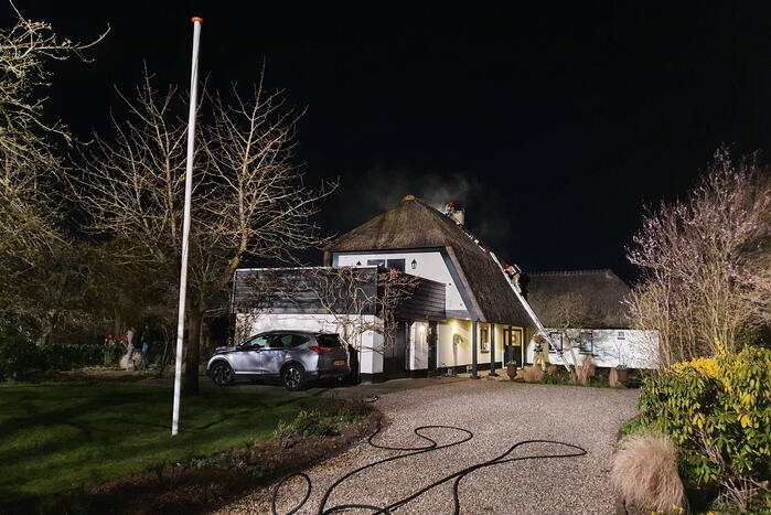 Brand in dak van villa met rietendak
