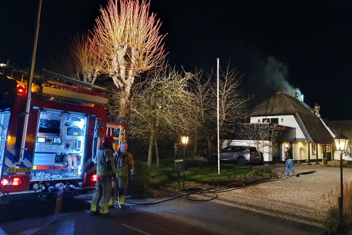 Brand in dak van villa met rietendak