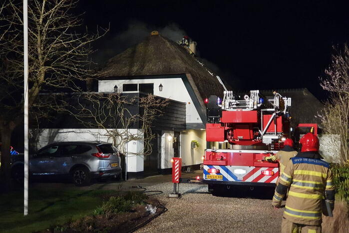 Brand in dak van villa met rietendak