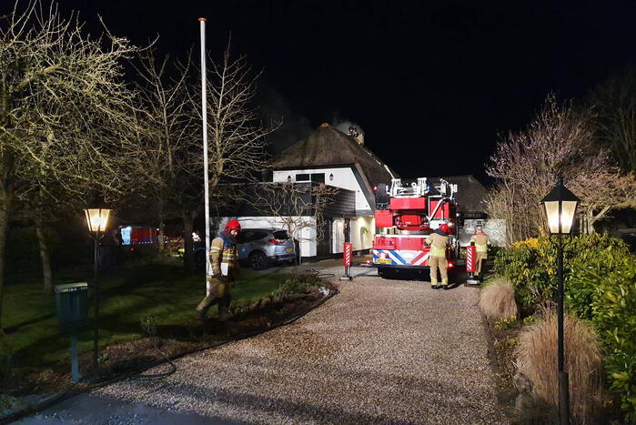 Brand in dak van villa met rietendak
