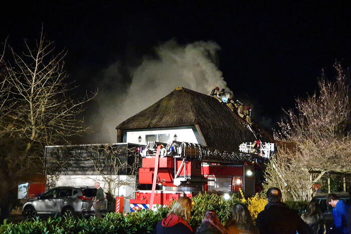 Brand in dak van villa met rietendak