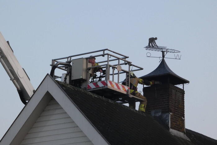 Brandweer blust brand in schoorsteen
