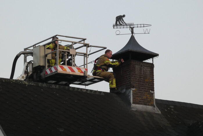 Brandweer blust brand in schoorsteen