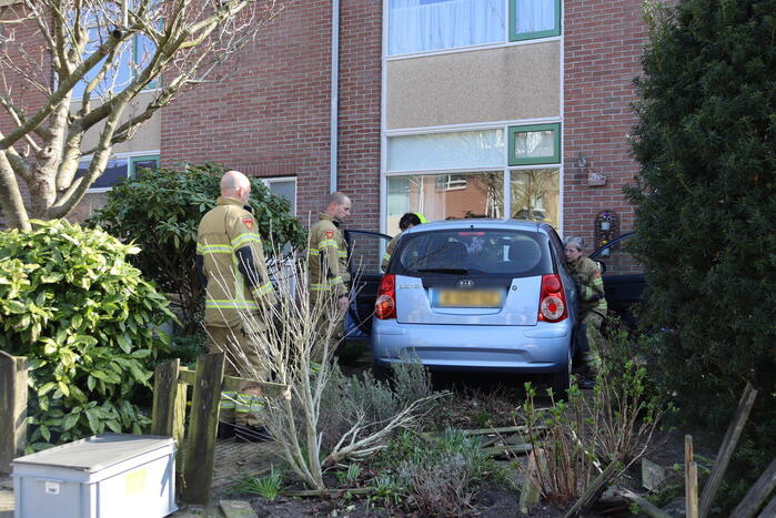Auto rijdt voortuin van huis binnen