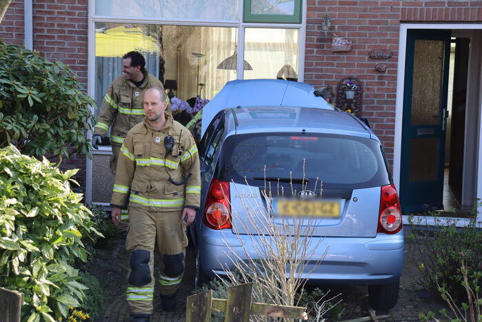 Auto rijdt voortuin van huis binnen