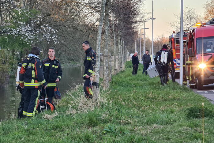 Driewieler aan waterkant, duikers zoeken naar slachtoffer