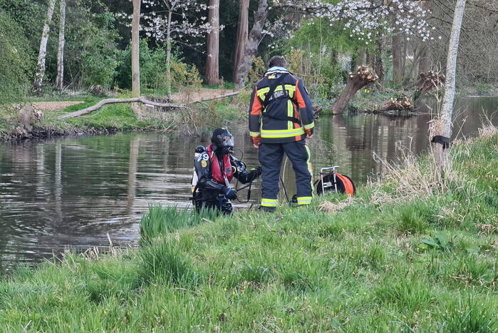 Driewieler aan waterkant, duikers zoeken naar slachtoffer