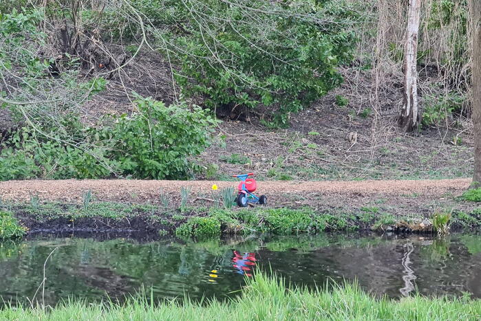 Driewieler aan waterkant, duikers zoeken naar slachtoffer