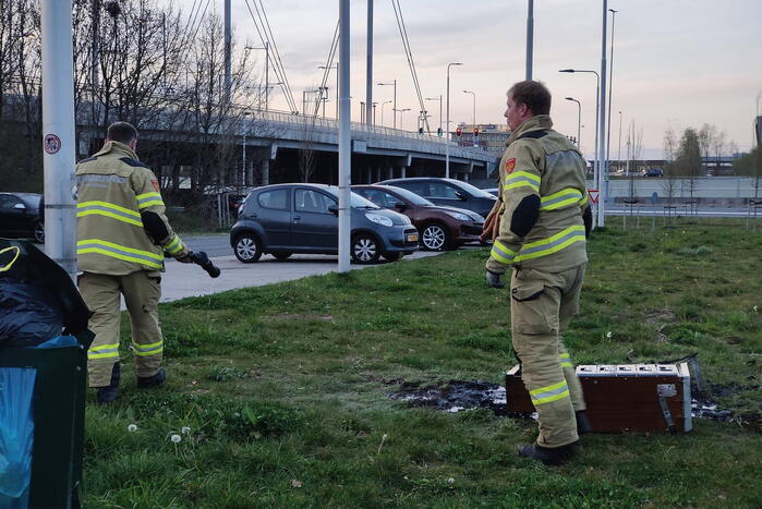 Brandweer blust brandende afvalcontainer