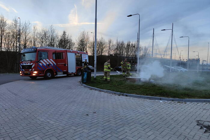 Brandweer blust brandende afvalcontainer