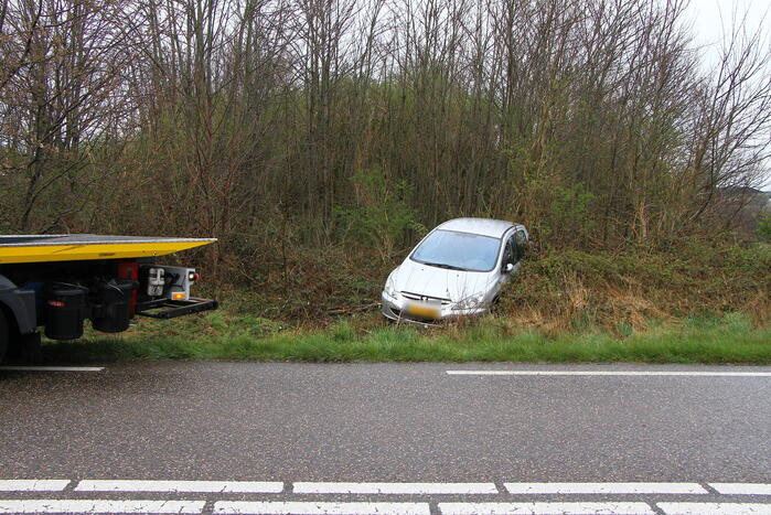 Auto raakt van de weg en belandt in bosjes