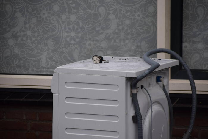 Wasmachine in woning vat vlam