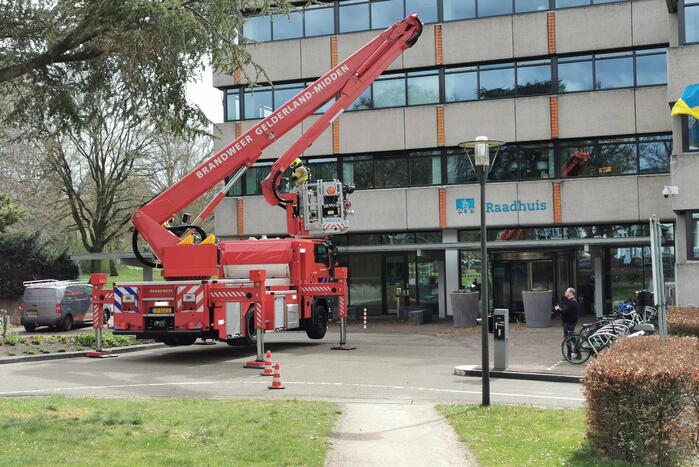 Brandweer zaagt gevaarlijk hangende tak uit boom voor gemeentehuis