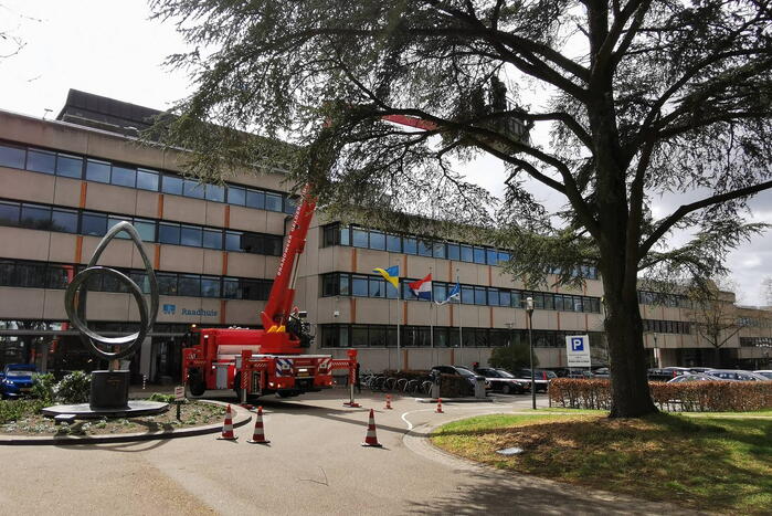Brandweer zaagt gevaarlijk hangende tak uit boom voor gemeentehuis