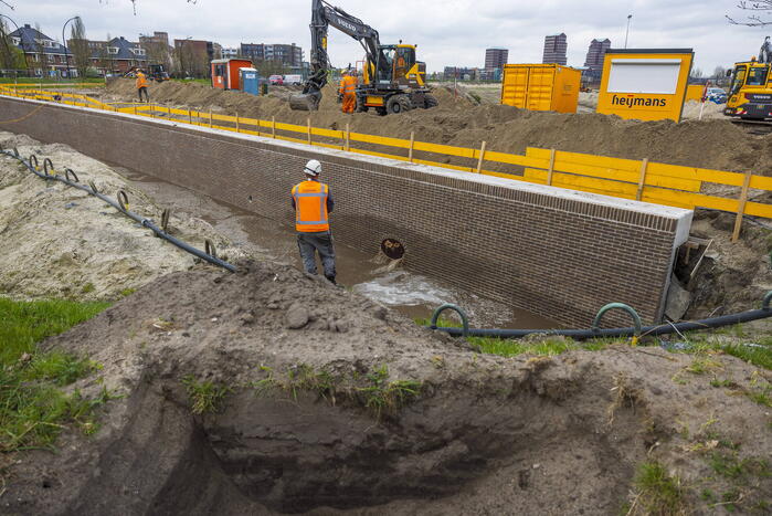 Water spuit uit nieuwe kademuur door gesprongen waterleiding