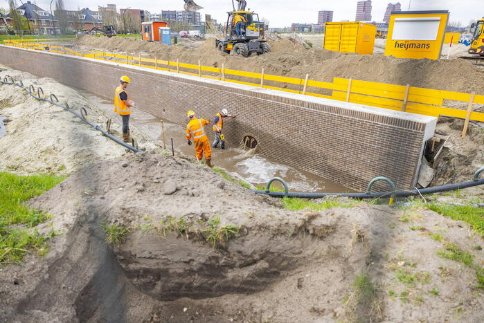 Water spuit uit nieuwe kademuur door gesprongen waterleiding
