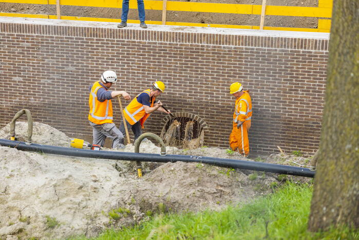 Water spuit uit nieuwe kademuur door gesprongen waterleiding