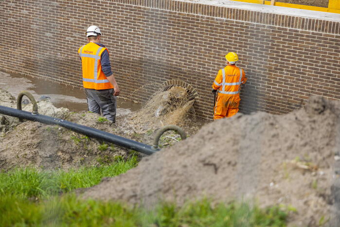 Water spuit uit nieuwe kademuur door gesprongen waterleiding