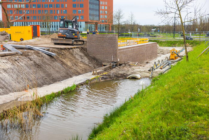 Water spuit uit nieuwe kademuur door gesprongen waterleiding