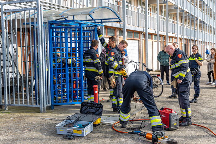 Kind met hoofd vast tussen draaideur