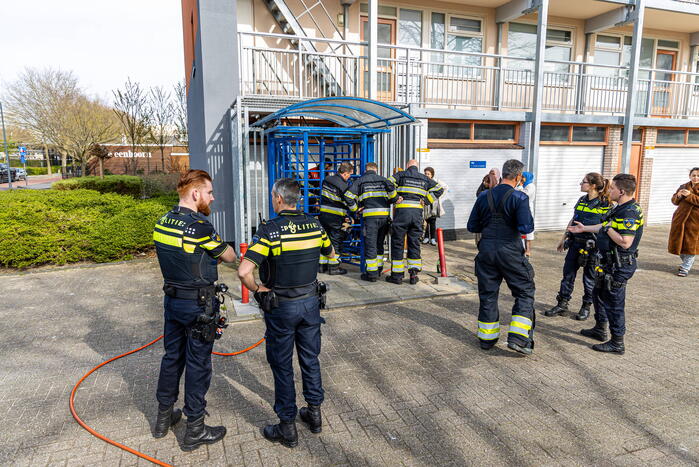 Kind met hoofd vast tussen draaideur