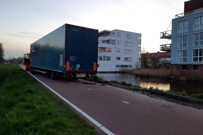 Vrachtwagen rijdt zich vast in berm