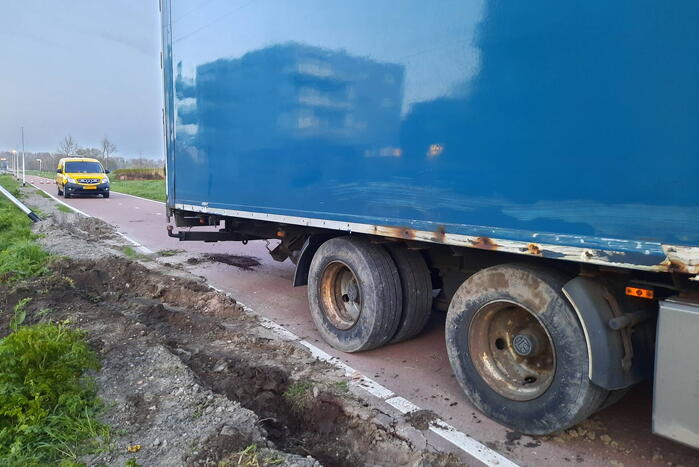 Vrachtwagen rijdt zich vast in berm