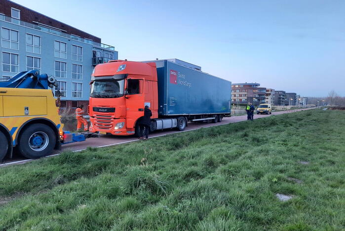 Vrachtwagen rijdt zich vast in berm