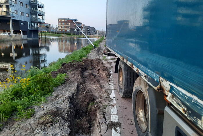 Vrachtwagen rijdt zich vast in berm