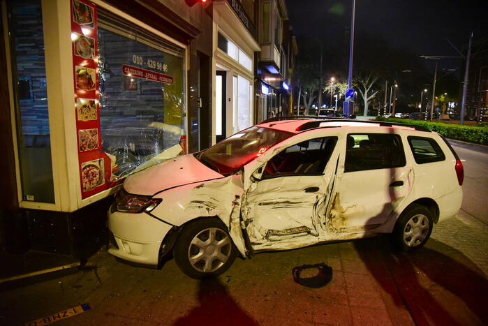 Auto knalt tegen winkelpand door botsing