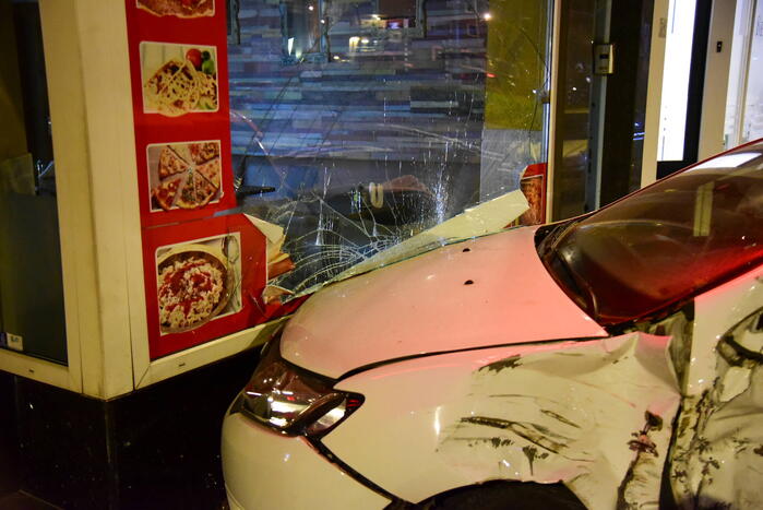 Auto knalt tegen winkelpand door botsing