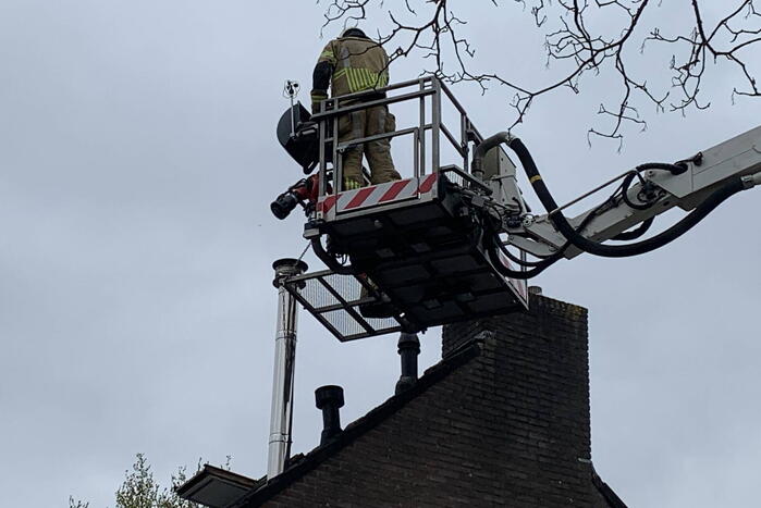 Brandweer veegt schoorsteen na brand