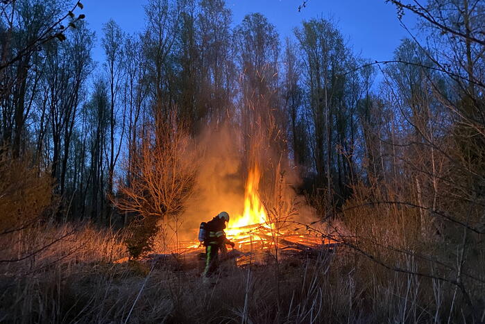 Stapel met hout vliegt in brand