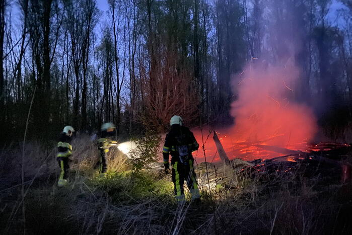 Stapel met hout vliegt in brand