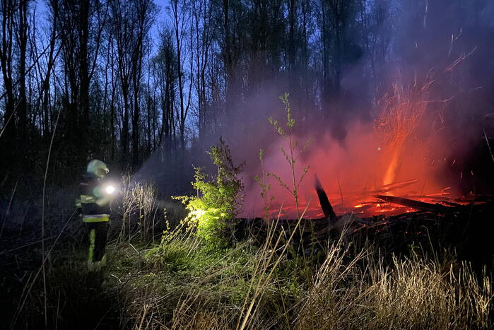 Stapel met hout vliegt in brand