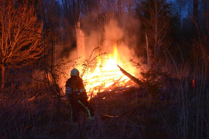 Stapel met hout vliegt in brand