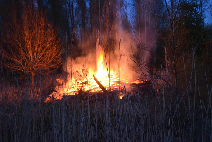 Stapel met hout vliegt in brand