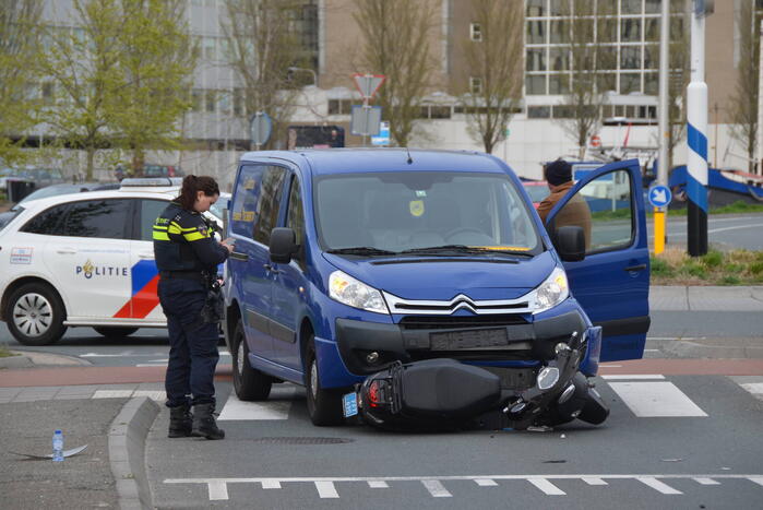 Scooter belandt onder bestelbus