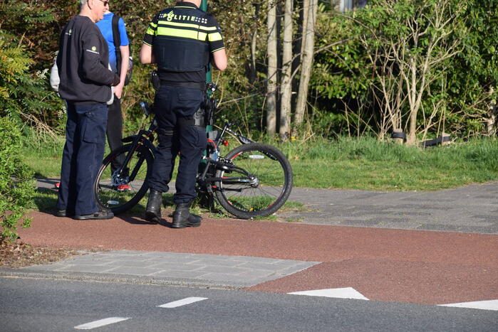 Jongeman op fiets vliegt over motorkap van auto